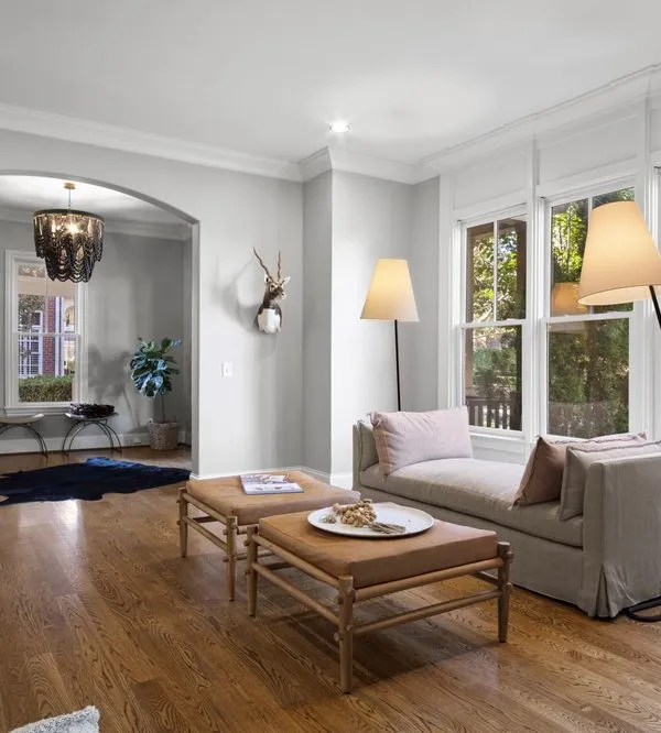 A finished living room with light gray walls, white trim and an arched doorway