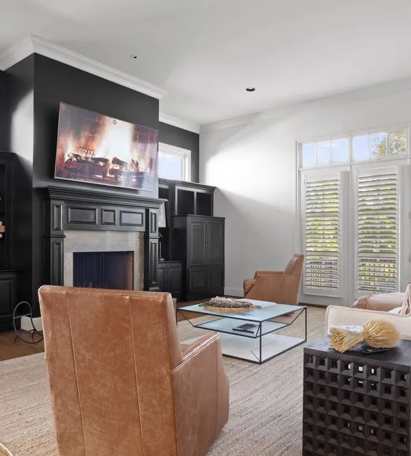 A finished family room with black built-ins, white walls and trim